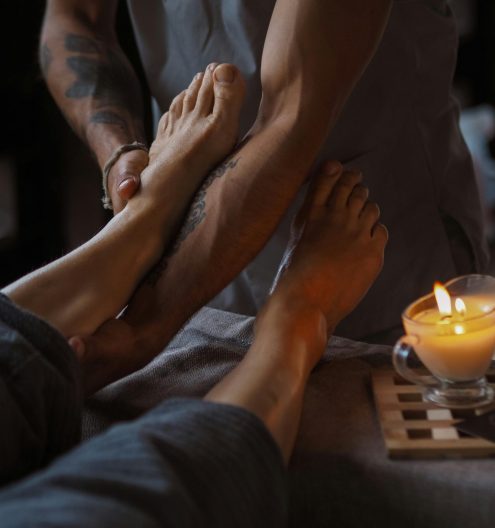A serene foot massage session lit by candlelight, ideal for relaxation and spa treatments.